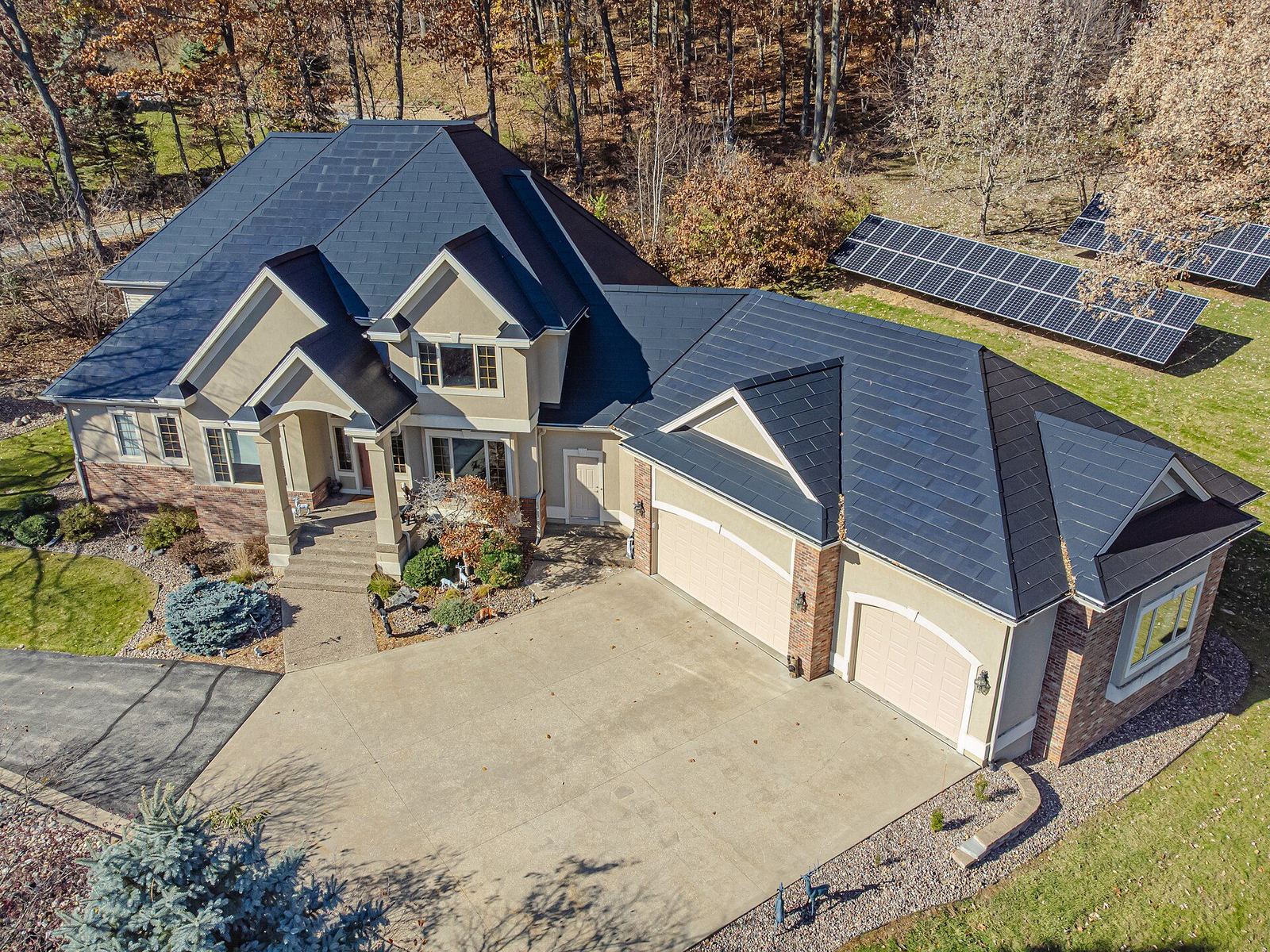 Beautiful home with Tesla Solar Roof fully integrated glass tiles — aerial drone view