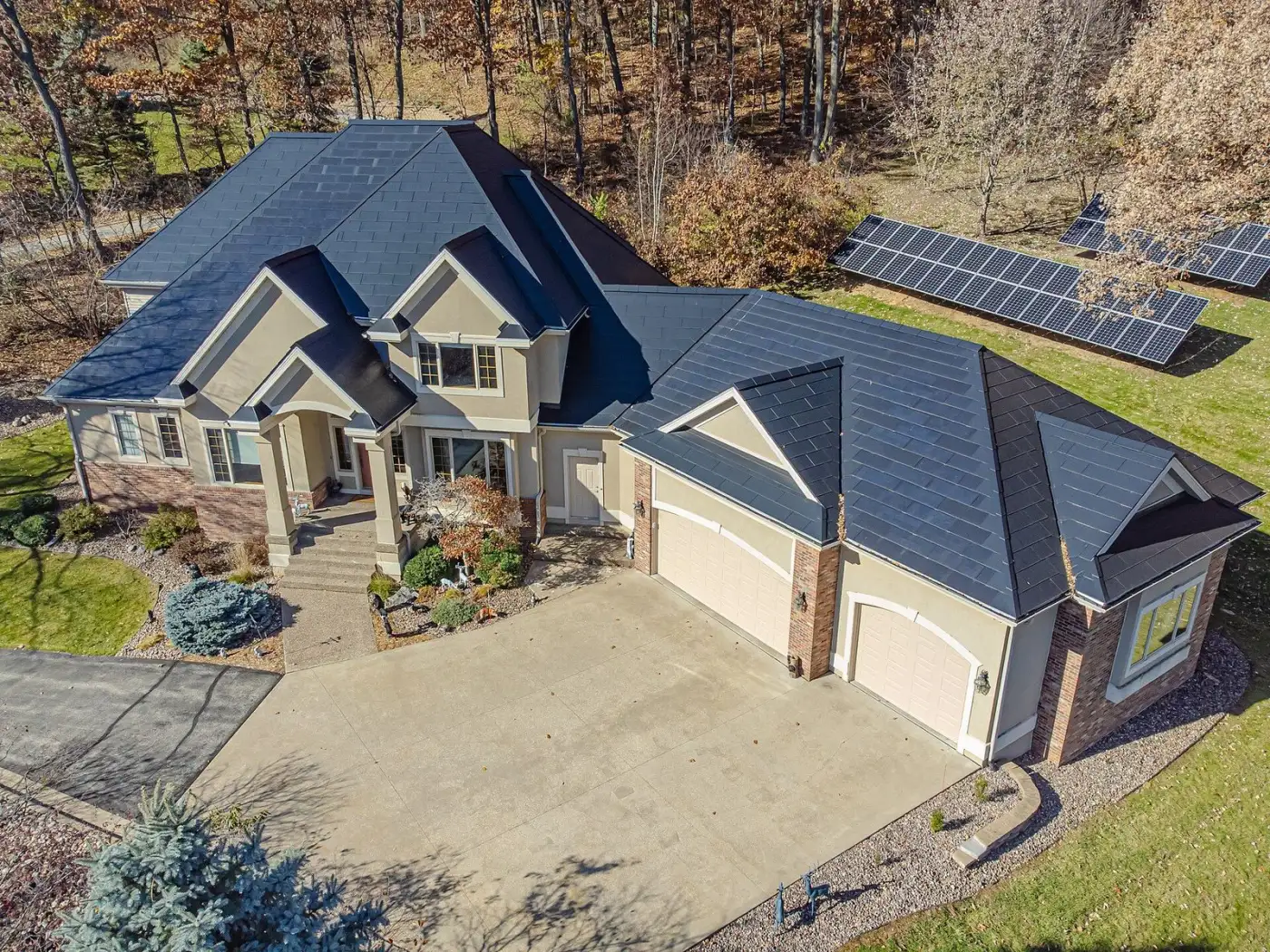 Beautiful home with Tesla Solar Roof fully integrated glass tiles — aerial drone view
